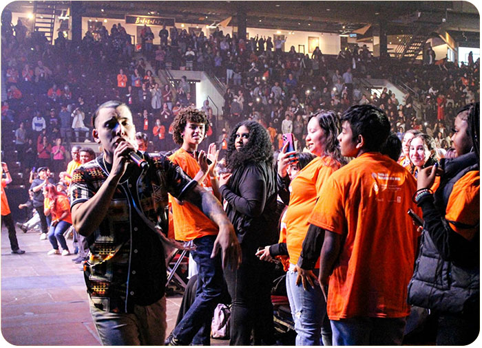 Singer walking beside crowd during TRW Youth Empowerment 2023